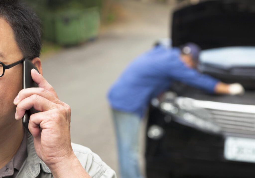 man calling beside his car