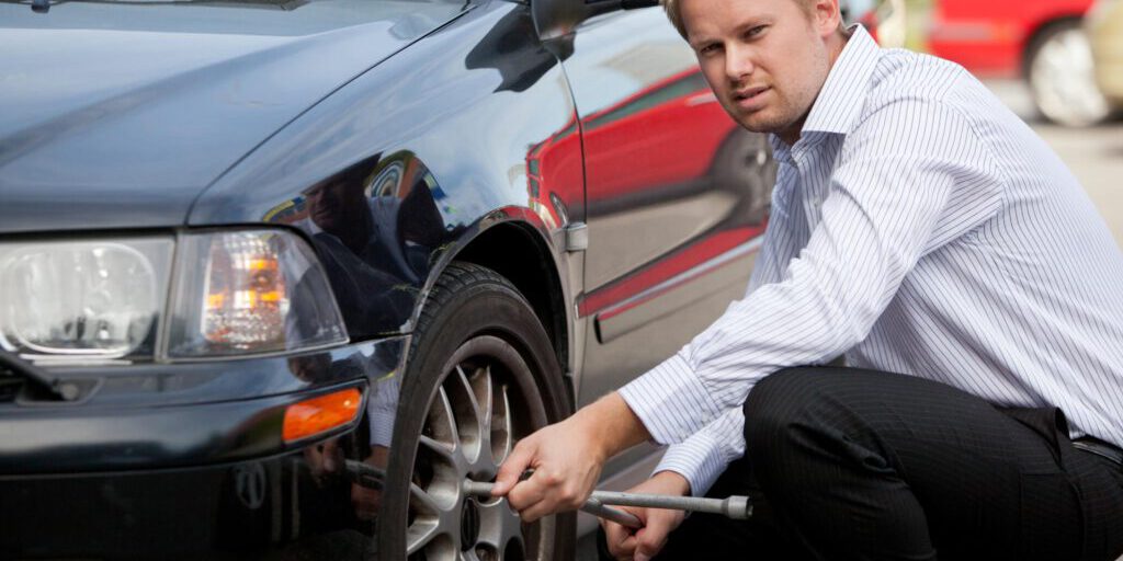 man repairing his car tire